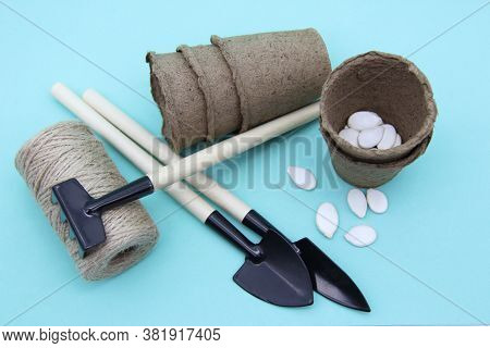 Garden Tools: Shovel, Rake, Peat Pots Isolated On A Soft Mint Background. Seeds And Home Gardening. 