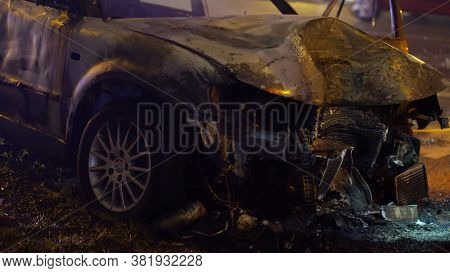 Front View Of The Car Burned After The Serious Car Accident At Night In Winter. High Quality Photo