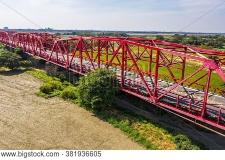 red famous Xilou Bridge over the river and farm in Yunlin county, Taiwan