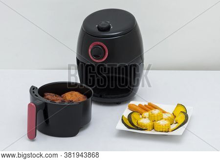 Air Fryer Machine With Chicken And Vegetables On White Background