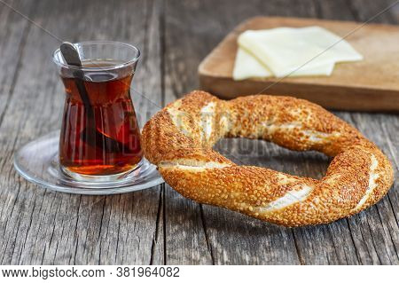 Crispy Turkish Traditional Bagel / Simit With Sesame And Glass Of Turkish Black Tea On Rustick Backg