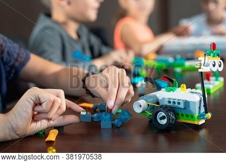 Children In The Classroom Collect Figure From The Designer.