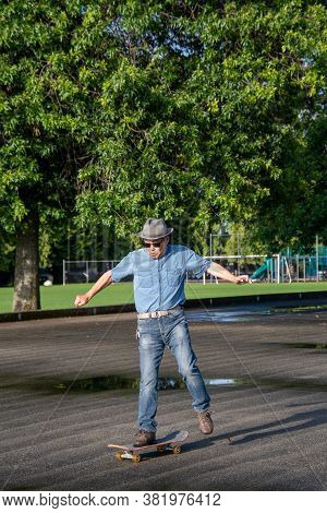 A Middle-aged Man Jumping Off Of His Skateboard Because He Lost His Balance.   Vancouver Bc Canada