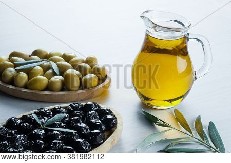 Glass Bottle Of Homemade Olive Oil And Olive Tree Branch, Raw Turkish Green Olive Seeds And Leaves O