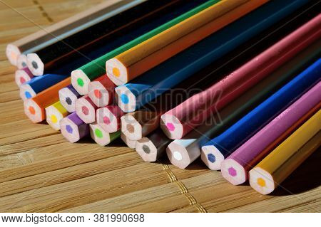Unsharpened Color Pencils In A Stack On A Wooden Background.