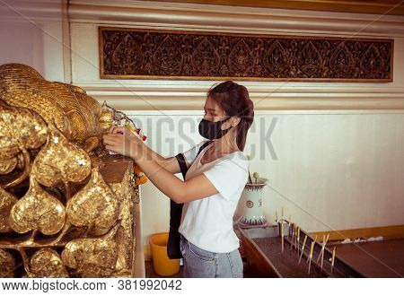 A Buddhist Woman Making Merit At A Temple And She Wears A Face Mask To Protect Against The Virus. Ba