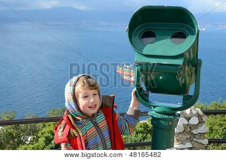 Niño está parado en el telescopio en Gibraltar