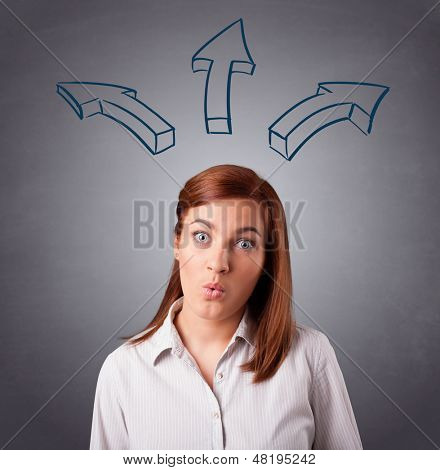 Schöne junge Dame, die mit Pfeilen overhead denken