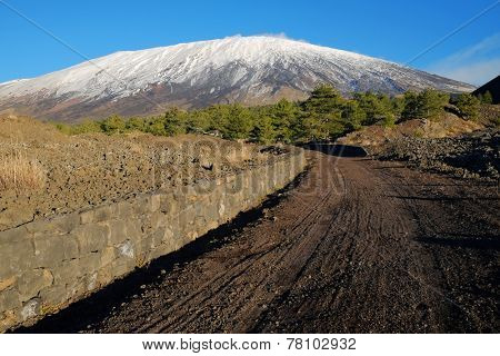 curve dirt track to the volcano Etna snow covered, Sicily