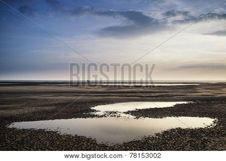 Conceptual Landscape Image Of Two People On Remote Beach