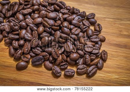 Arabica coffee beans spilled on table background