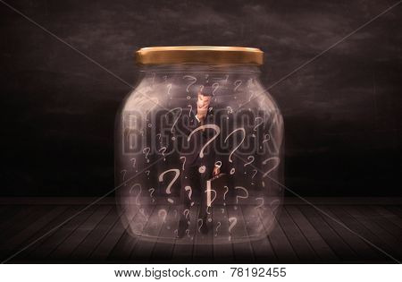 Businessman locked into a jar with question marks concept on background
