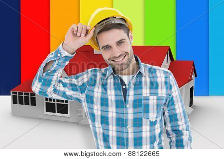 Confident male technicial wearing hard hat against digitally generated house