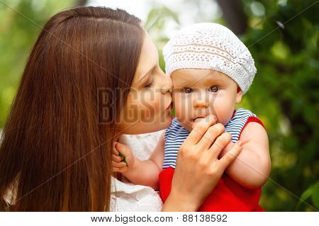 Cute Toddler Baby Sitting On Mom`s Hands