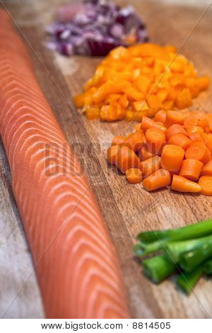 Saumon frais avec des légumes hachés sur une planche