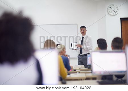 group of students with teacher in computer lab classrom learrning lessons,  get help and support