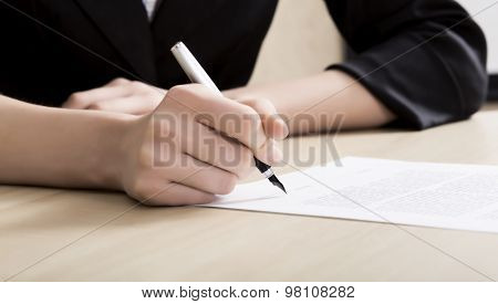 Female businessperson signs contract