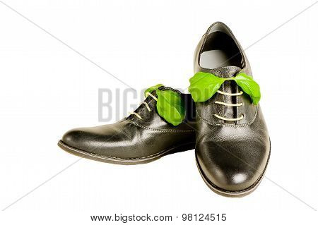 isolated italian leather shoes concept: boots laced with spaghetti and basil leaf as bow