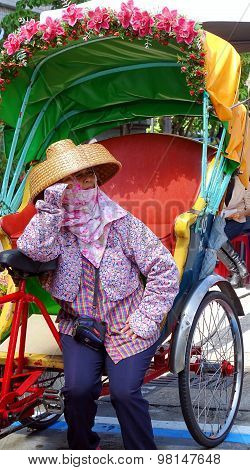 Female Pedicab Driver Waits For Customers