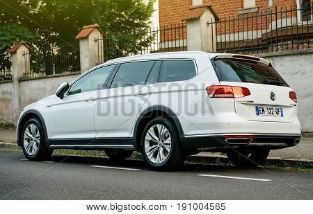 PARIS FRANCE - MAY 28 2017: View from below of white Volkswagen Passat Alltrack all four wheel drive car parked in city. The Passat Alltrack bridges the gap between the passenger VW range and the SUV range comprising the Tiguan and Touareg.