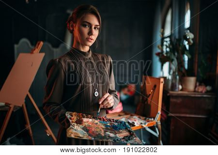 Female painter with brush and palette in hands