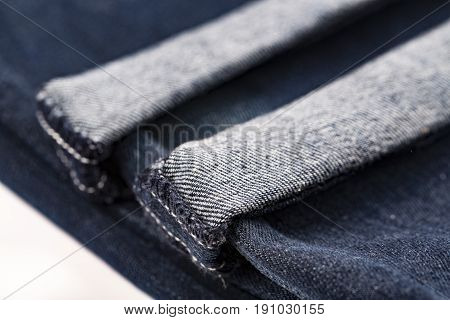 Denim blue jeans folded hemmed close up on with background