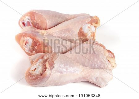 four raw chicken drumsticks isolated on white background.