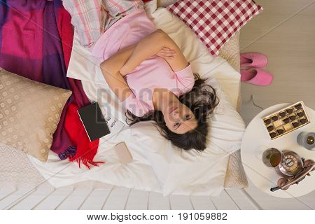 Depressed and sad lonely woman is lying in her bed