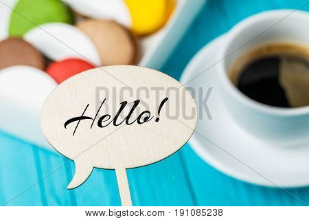 Wooden topper with inscription on background of makaruns and cup of coffee