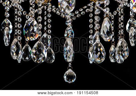 Large crystal chandelier close-up in baroque style isolated on black background. Luxury royal expensive chandelier for living room, Hall of celebration.