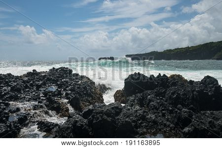 Black lava rocks line the shore at Keanae on the road to Hana in Maui, Hawaii