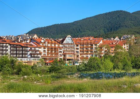 Bansko, Bulgaria - June 13, 2017: St. Ivan Rilski hotel and green pine trees mountains panorama in bulgarian ski resort Bansko