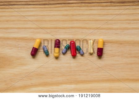 Lot Of Colorful Pills On A Wooden Table