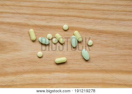 Lot Of Colorful Pills On A Wooden Table