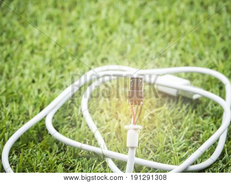 white USB cable damaged left on green grass