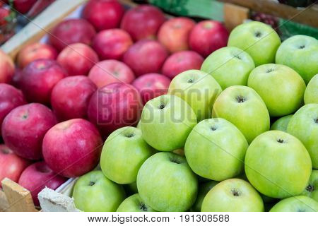 Red and green apples on the tray in the market.