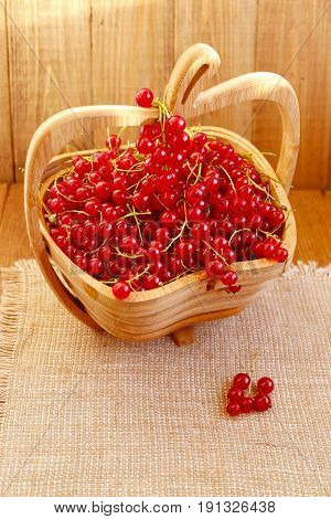 clusters of fresh ripe berries of red currant on the wooden vase