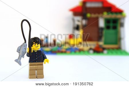 Colorado, USA - June 14, 2017: Studio shot of cute LEGO minifigure boy fishing with cabin in the background.