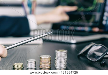 Stock trader pointing pen up as his money profit growing up