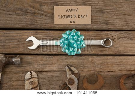 Happy fathers day message with old and new worktools on wooden plank