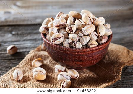 Pistachios In Wooden Bowl Over Wooden Background, Selective Focus.