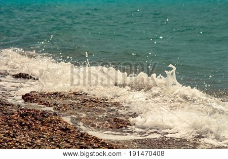 Breaking big waves sunlit sea foam in summer