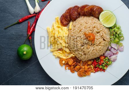 Rice Seasoned with Shrimp Paste Thai food on white dish over dark granite table.