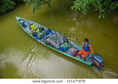 CUYABENO, ECUADOR - NOVEMBER 16, 2016: Unidentified man travelling by boat into the depth of Amazon Jungle in Cuyabeno National Park, Ecuador.