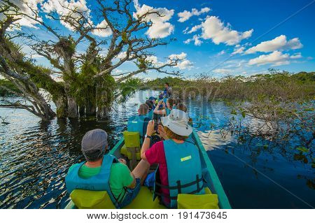 CUYABENO, ECUADOR - NOVEMBER 16, 2016: Unidentified people travelling by boat into the depth of Amazon Jungle in Cuyabeno National Park, Ecuador.