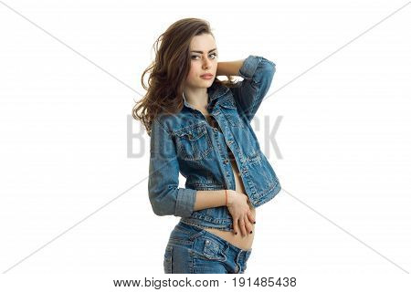 beautiful brunette in jeans jacket erotic poses in the Studio and looking at camera isolated on white background