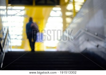 Figure of a person emerging from an underground passage. Blurred cityscape background
