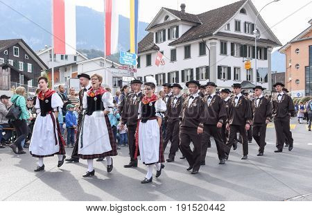 People Wearing Traditional Clothes And Singing In A Parade