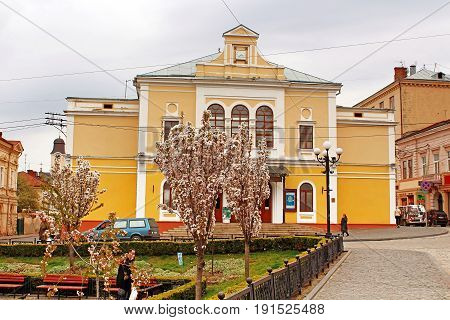 CHERNIVTSI, UKRAINE - APRIL 22, 2017: The view of Philharmonic hall from the Philharmonic square where tourists and locals like to feed the pigeons
