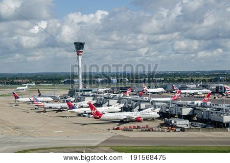 LONDON UK - JUNE 3 2017: View from the air of planes parked at Terminal 3 of London's Heathrow Airport on a sunny summer morning. Virgin Atlantic Delta and American Airlines all use this part of the busy airport.